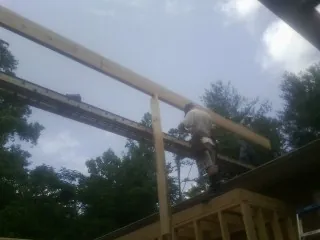 Carpenter setting a ridge beam over a new addition frame — Ice Dam Removal by Roofing Brothers in Fort Lawn