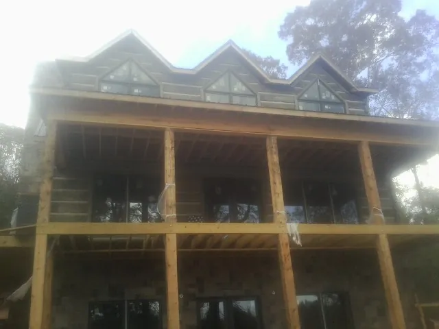Dormers and porch framing on a large log home under construction — Roof Coating work by our crew in Fort Lawn