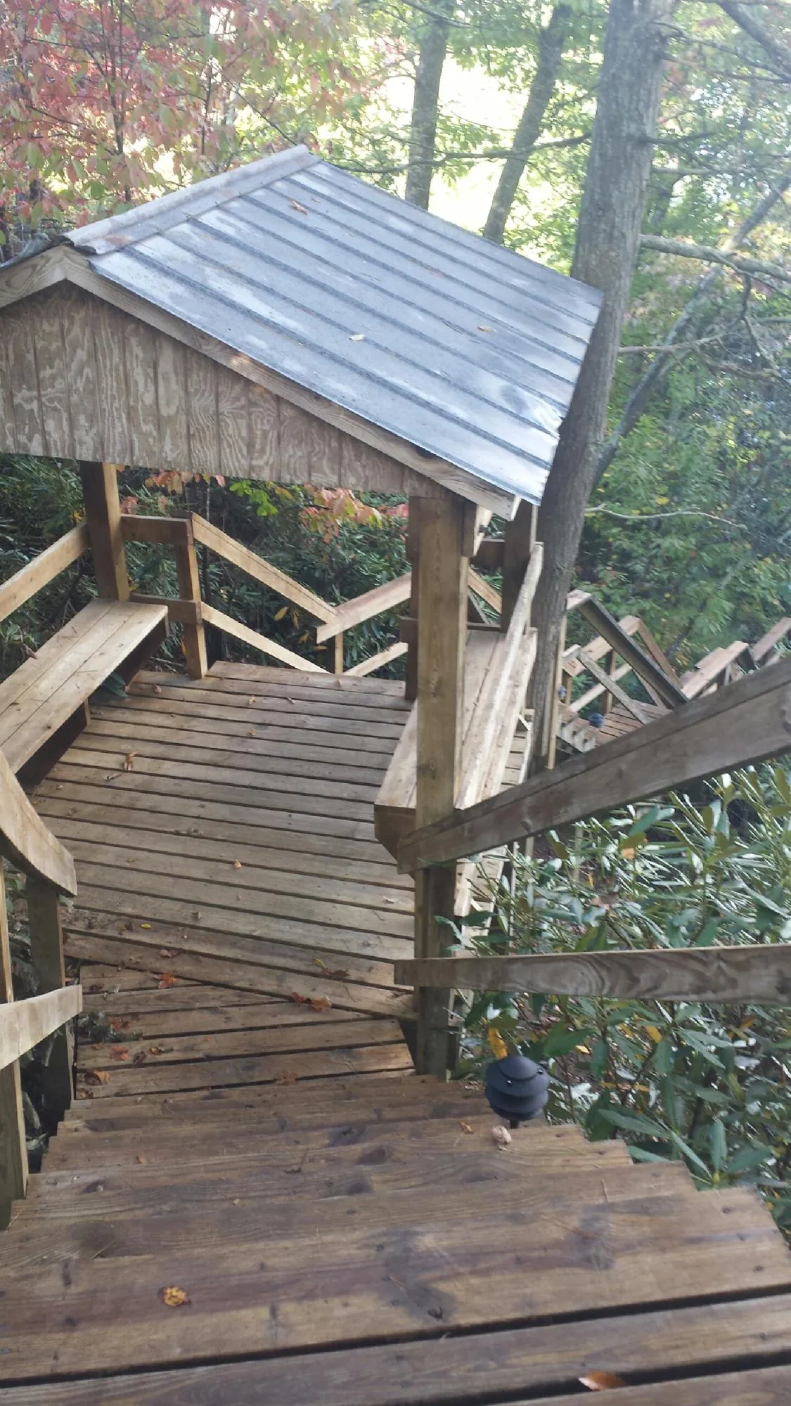 Metal roofed shelter over wooden steps on a wooded walkway — Skylight Repair & Installation work by our crew in Fort Lawn